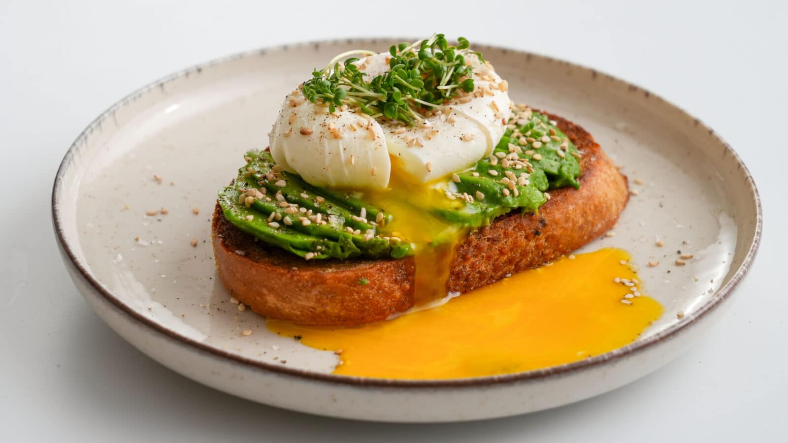 Pocheret æg med flydende blomme på en avocadomad